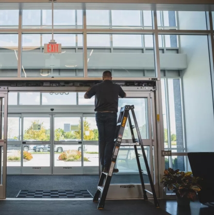Technician performing automatic door repair in Glenwood Springs business