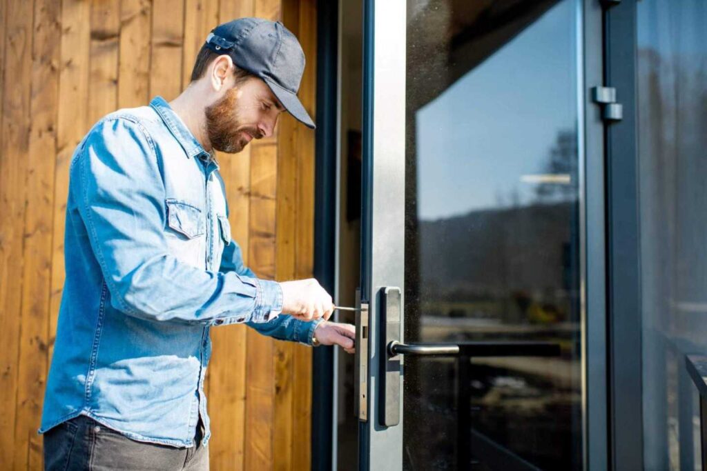Technician performing storefront door repair at a Glenwood Springs business