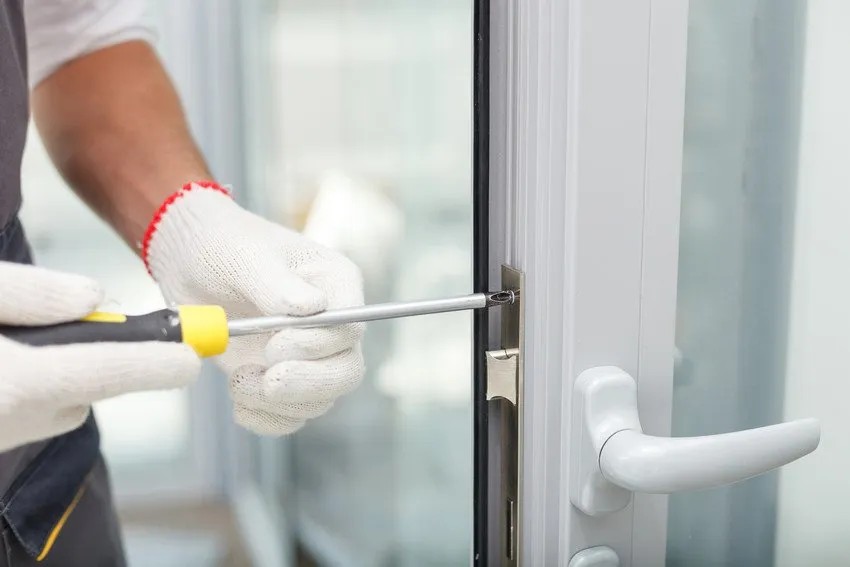 Technician performing door repair in a Rifle home
