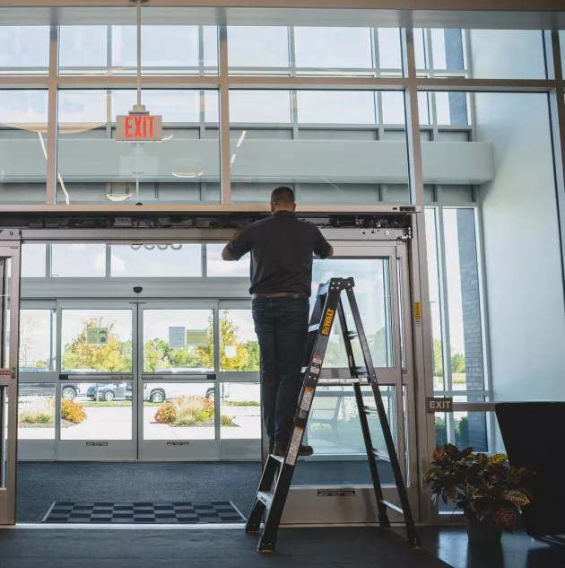 Technician repairing an aluminum storefront door in Grand Junction
