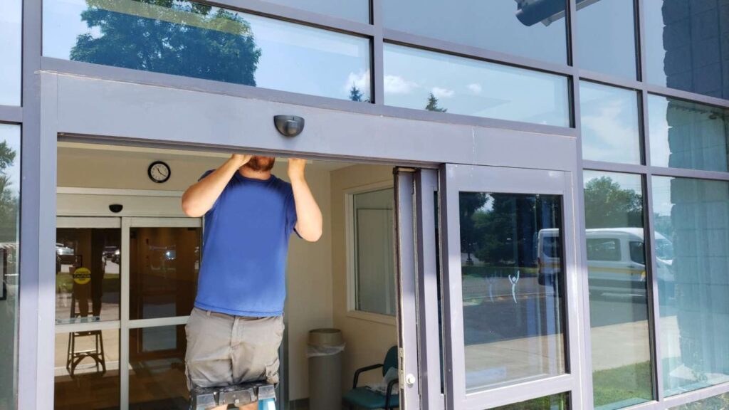 Technician repairing a commercial door that won’t close in Grand Junction