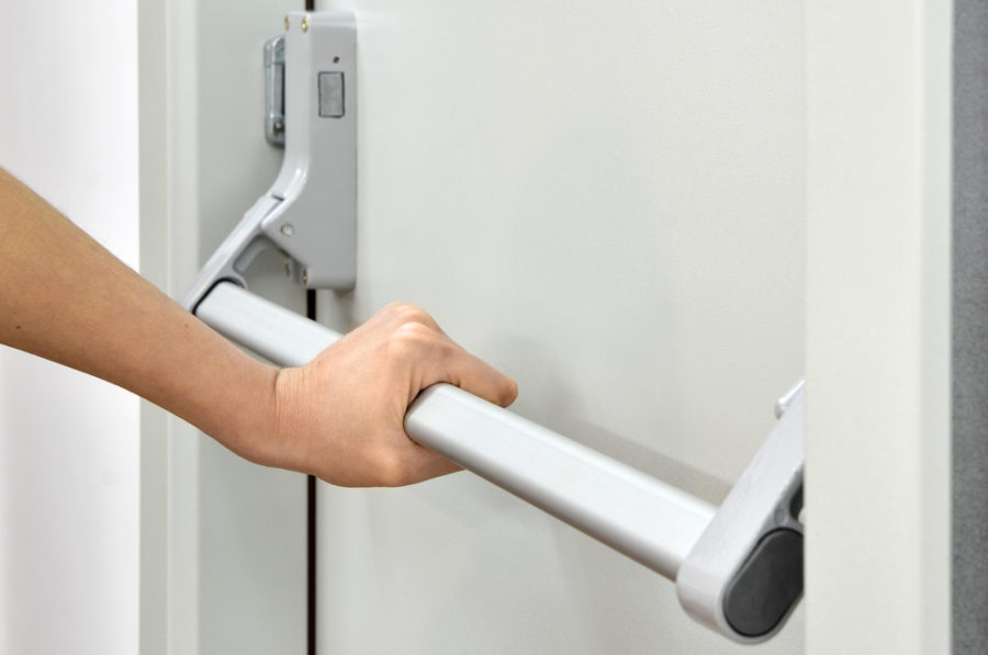 Technician repairing a panic bar on a commercial door in Grand Junction