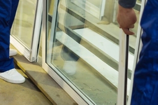 Technician repairing broken storefront glass in Grand Junction